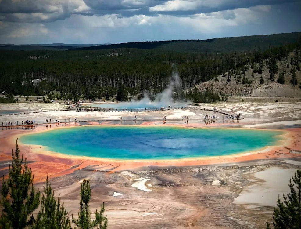 Free Aerial view of the vibrant Grand Prismatic Spring in Yellowstone National Park showcasing colorful geothermal features. Stock Photo